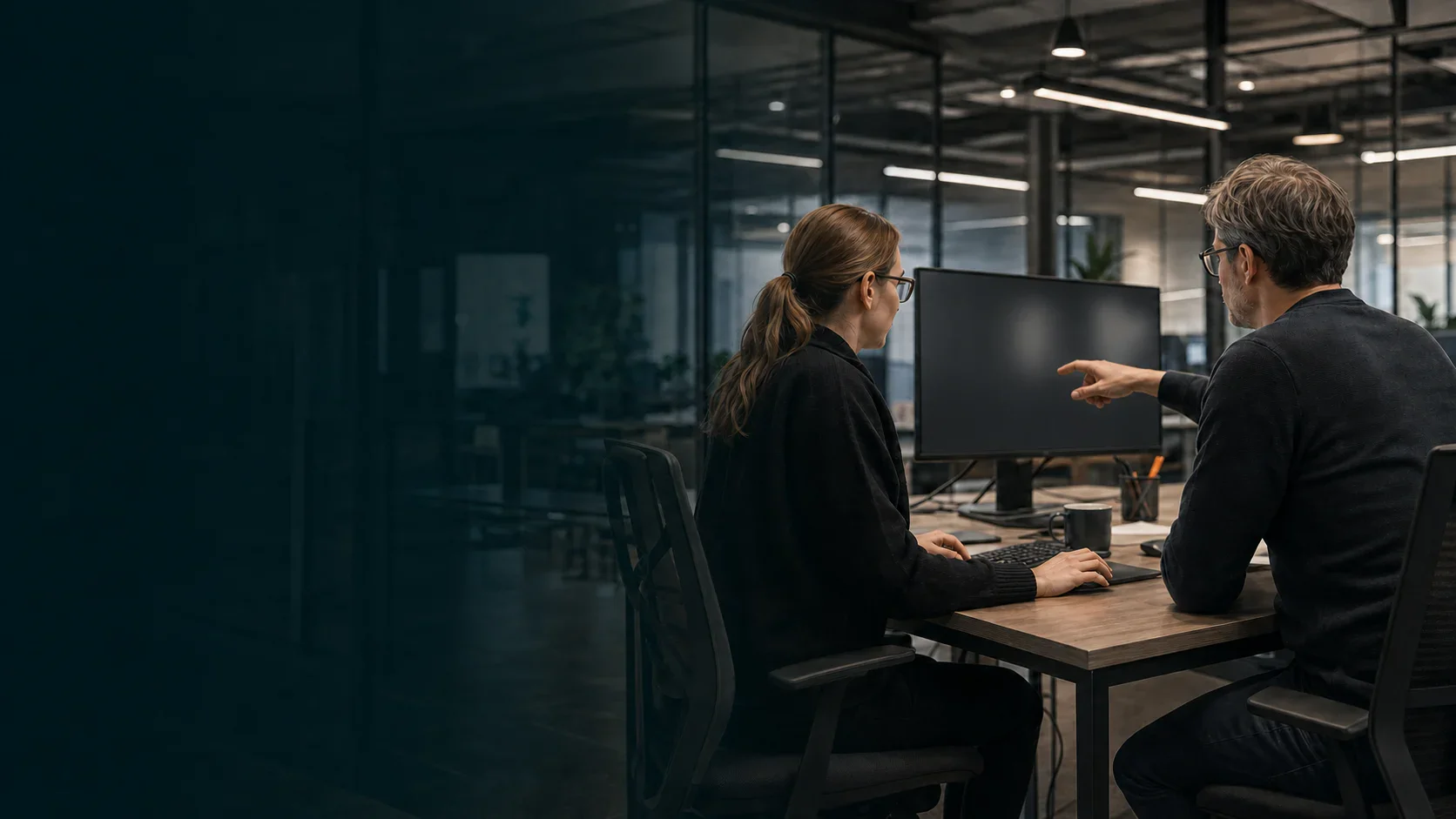 Two enterprise software engineers reviewing a system workflow in a modern engineering studio